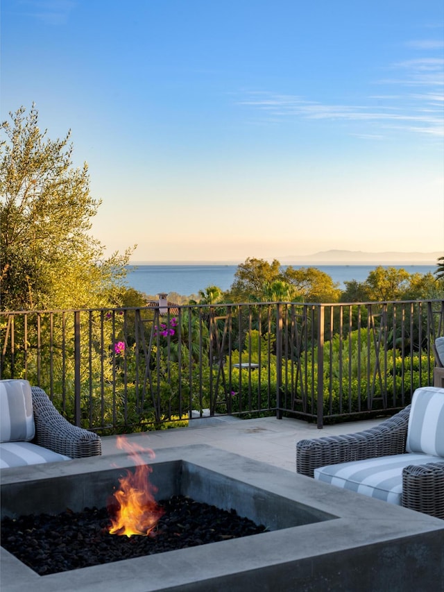 view of patio / terrace with a water view and a fire pit