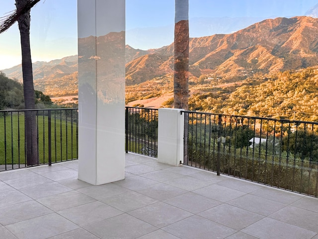 view of patio with a balcony and a mountain view