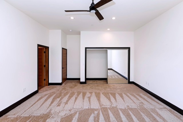 unfurnished bedroom with ceiling fan and light carpet