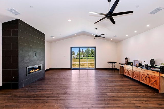 living room with ceiling fan, sink, a fireplace, dark hardwood / wood-style floors, and lofted ceiling