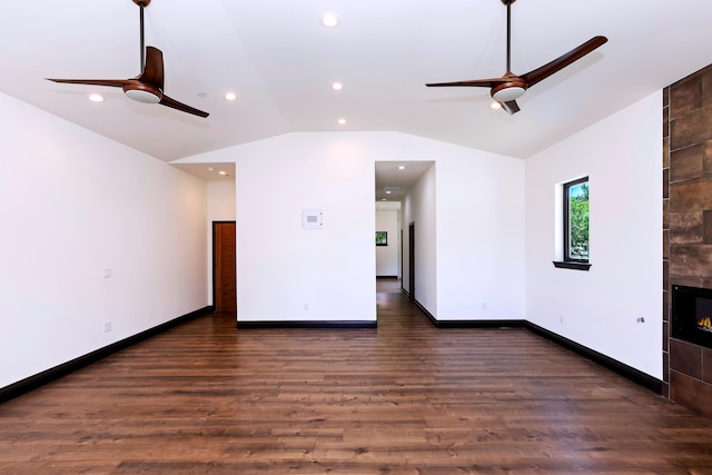 unfurnished living room with lofted ceiling, ceiling fan, dark wood-type flooring, and a tiled fireplace