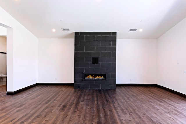 unfurnished living room featuring a fireplace and dark wood-type flooring