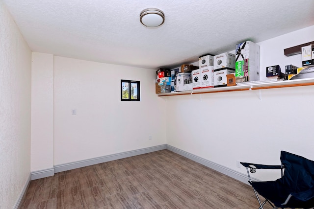 interior space with a textured ceiling and hardwood / wood-style flooring