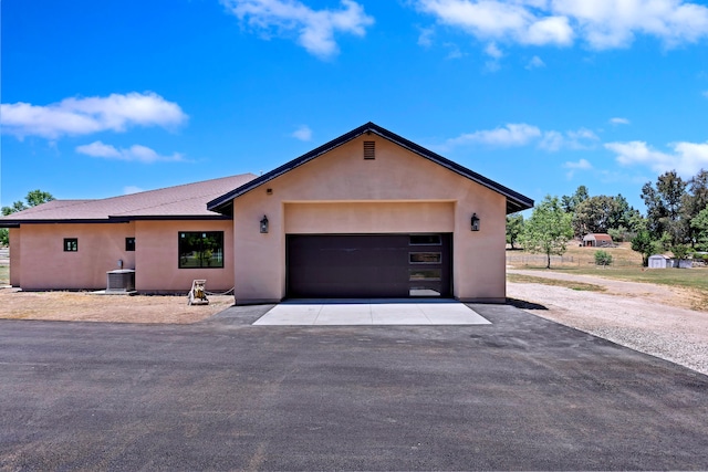 view of front facade featuring a garage and central AC