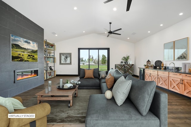 living room with dark wood-type flooring, a tile fireplace, sink, wine cooler, and vaulted ceiling