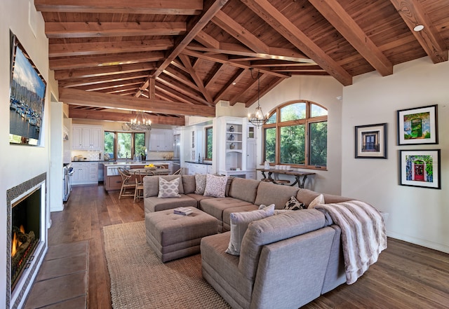 living room featuring dark wood-type flooring, wooden ceiling, beam ceiling, a chandelier, and high vaulted ceiling