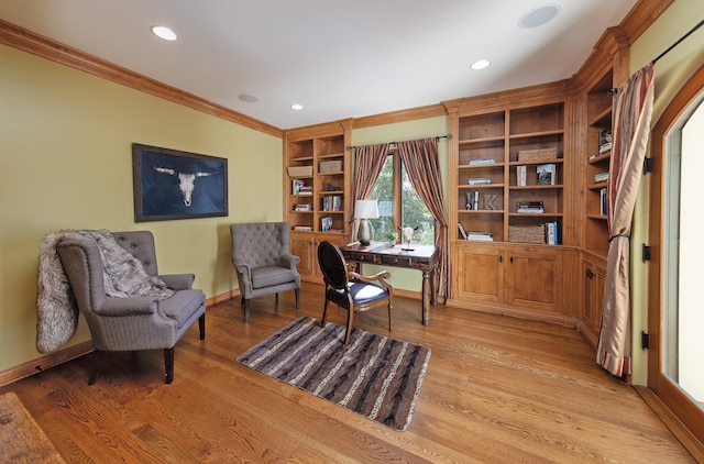 living area with built in shelves, ornamental molding, and light hardwood / wood-style floors