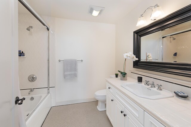 full bathroom featuring tile flooring, bathing tub / shower combination, toilet, and vanity with extensive cabinet space