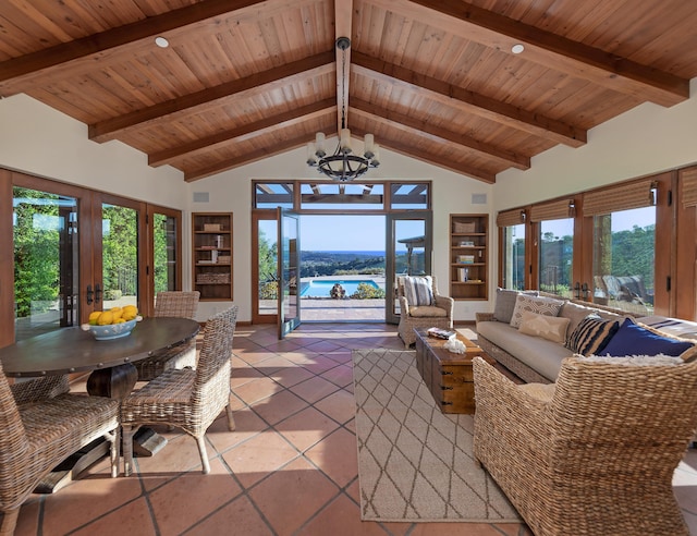 living room featuring beamed ceiling, a healthy amount of sunlight, tile flooring, and a water view