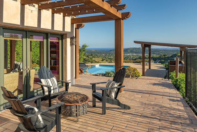 view of terrace featuring a pergola, a mountain view, a fire pit, and a fenced in pool