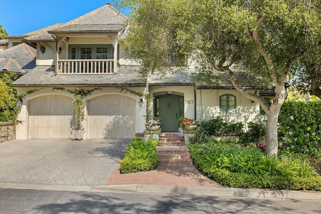 view of front of property featuring a garage and a balcony