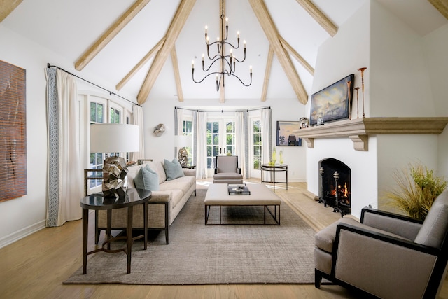 living room featuring a wealth of natural light, french doors, light hardwood / wood-style floors, and an inviting chandelier