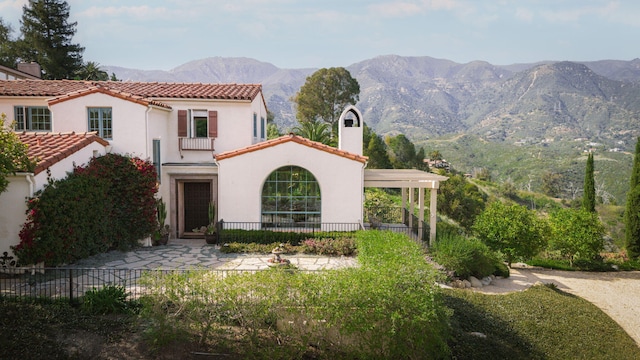 view of front facade featuring a mountain view and a balcony