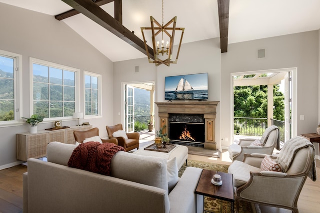 living room featuring a chandelier, wood-type flooring, beamed ceiling, and a premium fireplace