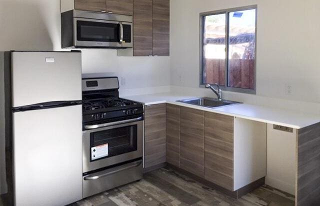 kitchen with dark hardwood / wood-style flooring, sink, and appliances with stainless steel finishes