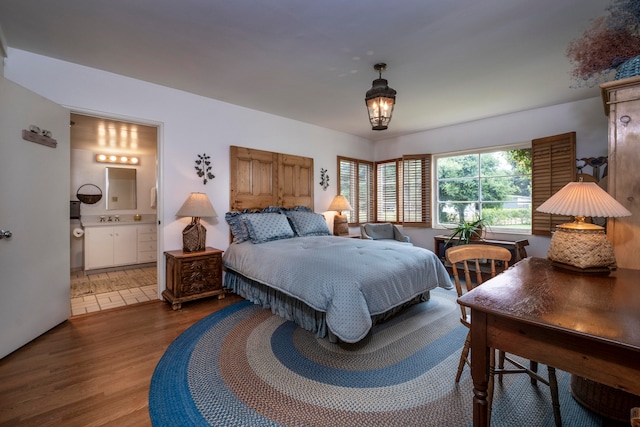 bedroom featuring tile patterned floors, sink, and ensuite bath