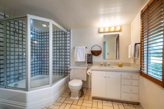 full bathroom featuring vanity, shower / bath combination with glass door, toilet, and tile patterned flooring