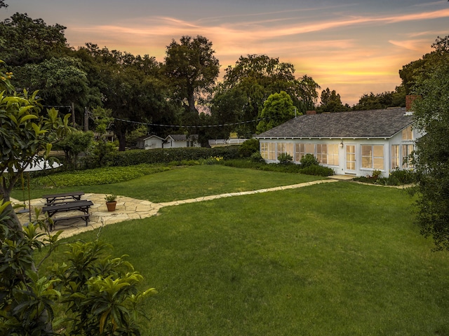 yard at dusk featuring a patio