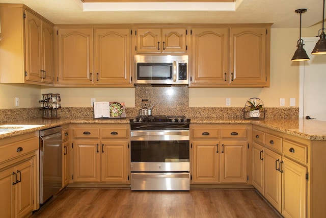 kitchen featuring light stone countertops, decorative light fixtures, stainless steel appliances, and dark wood-type flooring