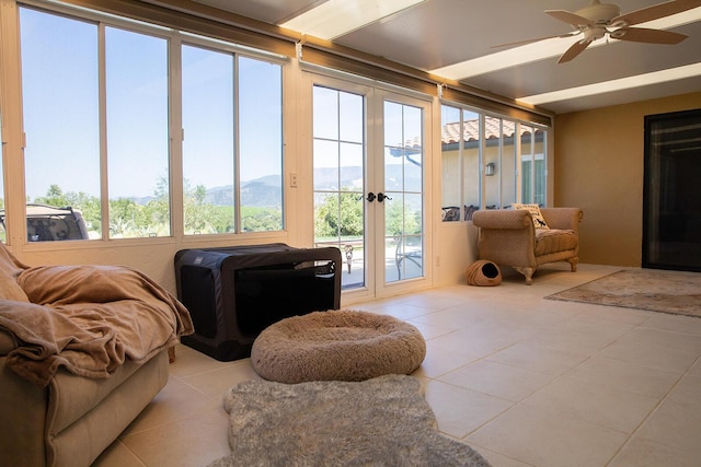 sunroom with ceiling fan and a mountain view