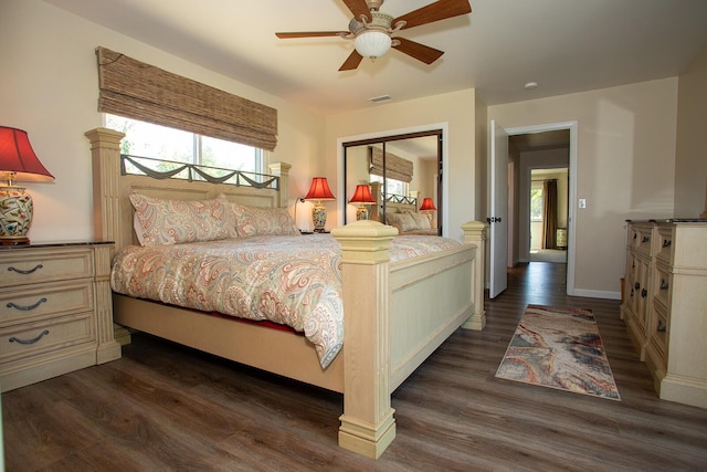 bedroom with ceiling fan, dark wood-type flooring, and a closet