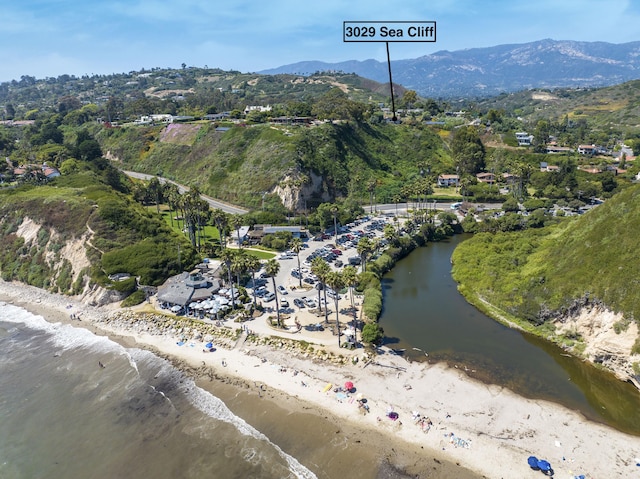 birds eye view of property featuring a water and mountain view and a beach view