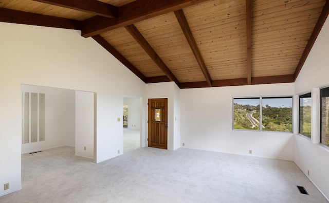 spare room with beamed ceiling, high vaulted ceiling, light colored carpet, and wood ceiling