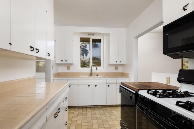 kitchen featuring white cabinetry, sink, and black appliances