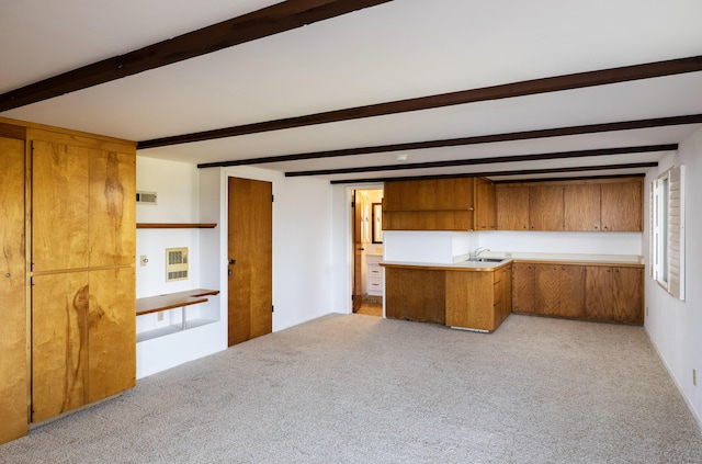 kitchen featuring light carpet, sink, and beam ceiling