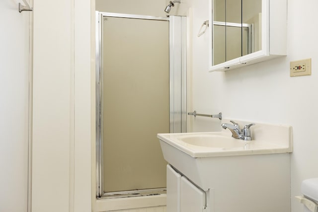 bathroom with vanity, toilet, and an enclosed shower