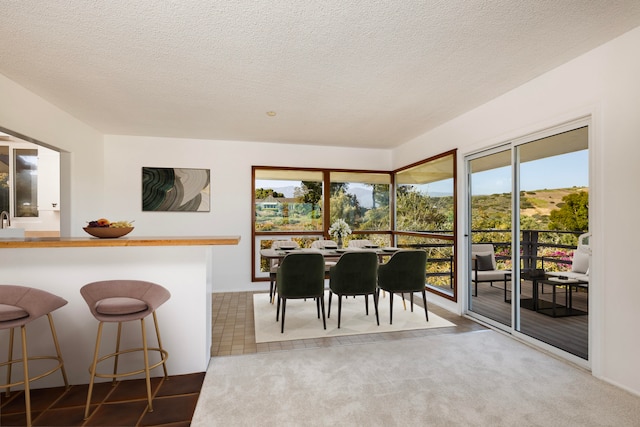 dining space with carpet floors and a textured ceiling