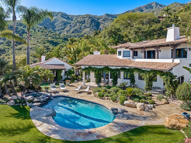 view of pool featuring a mountain view and a patio area