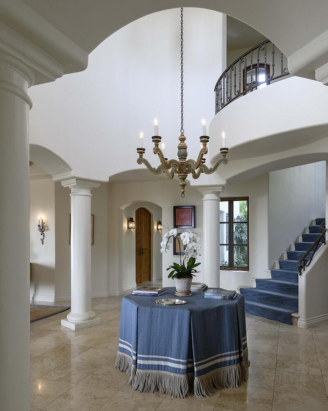 dining area featuring a notable chandelier and a towering ceiling