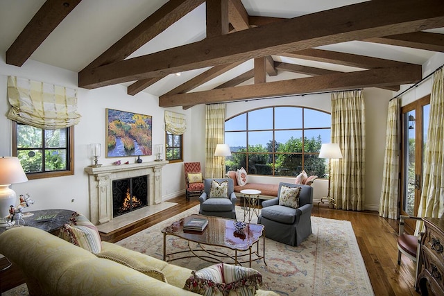 living room with a fireplace, lofted ceiling with beams, and wood-type flooring