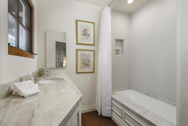 bathroom featuring shower / bathtub combination with curtain, hardwood / wood-style floors, and vanity