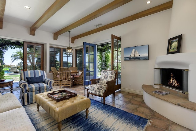 interior space featuring beamed ceiling, french doors, and a fireplace