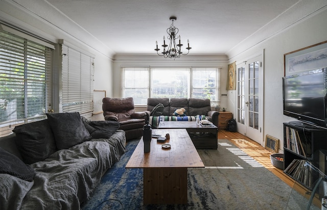 living room featuring a notable chandelier, visible vents, french doors, ornamental molding, and dark wood finished floors