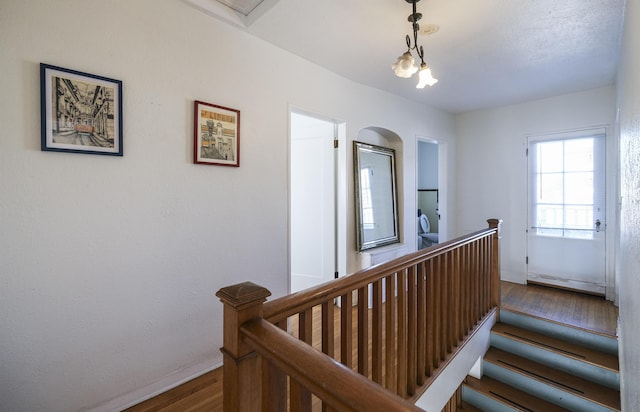 staircase featuring baseboards, baseboard heating, and wood finished floors