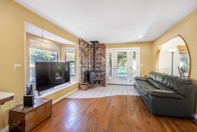 living room featuring a wood stove, light hardwood / wood-style floors, and plenty of natural light