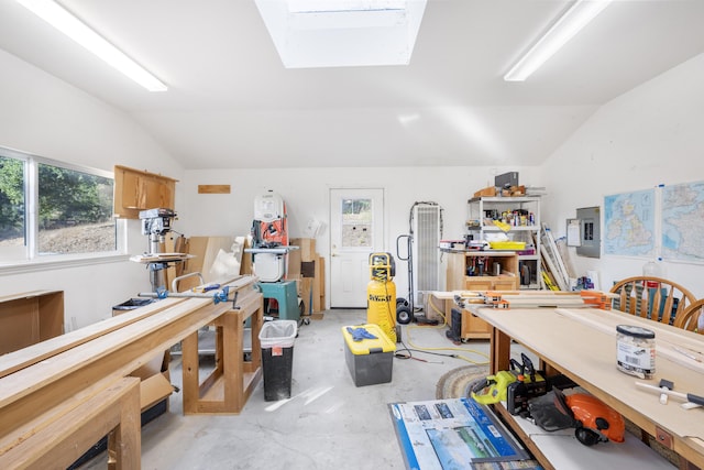 miscellaneous room featuring a wealth of natural light, a workshop area, electric panel, and vaulted ceiling with skylight