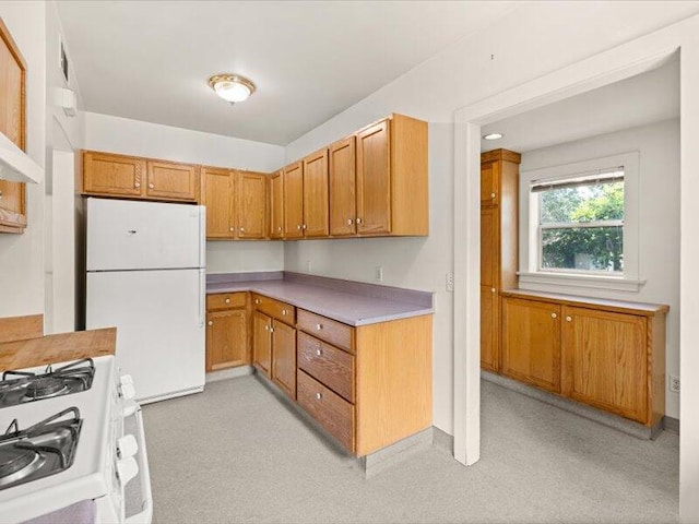 kitchen with light countertops, white appliances, and brown cabinets