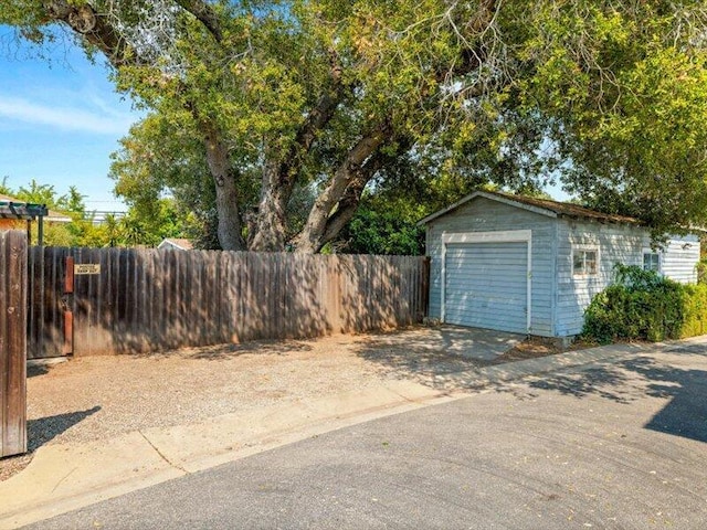 detached garage with fence and concrete driveway