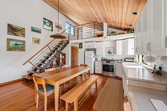 dining space with a high ceiling, wooden ceiling, dark hardwood / wood-style flooring, and sink