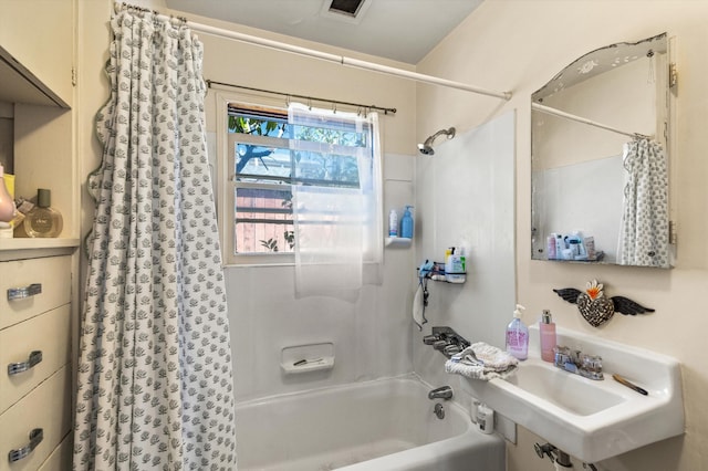 bathroom with shower / tub combo with curtain and sink