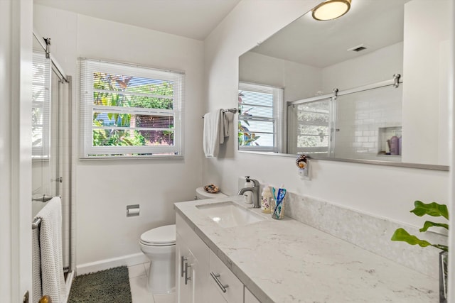 bathroom with vanity, tile patterned flooring, toilet, and a healthy amount of sunlight