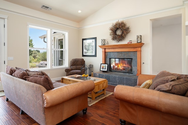 living room with a tile fireplace, dark wood-type flooring, and lofted ceiling