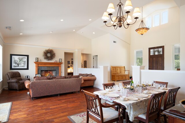 dining room with a chandelier, high vaulted ceiling, and dark wood-type flooring