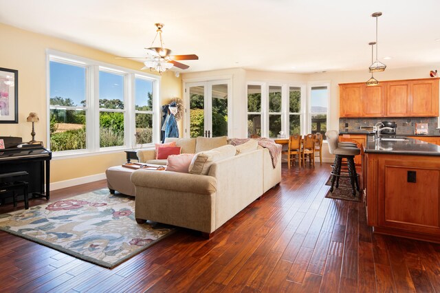 living room featuring dark wood-type flooring, sink, and ceiling fan