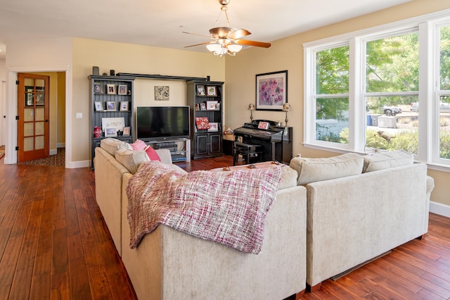 living room with dark wood-type flooring and ceiling fan