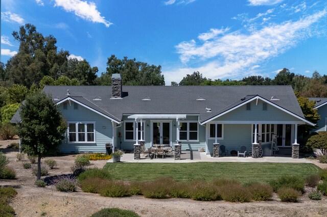 back of house with a patio area and a lawn